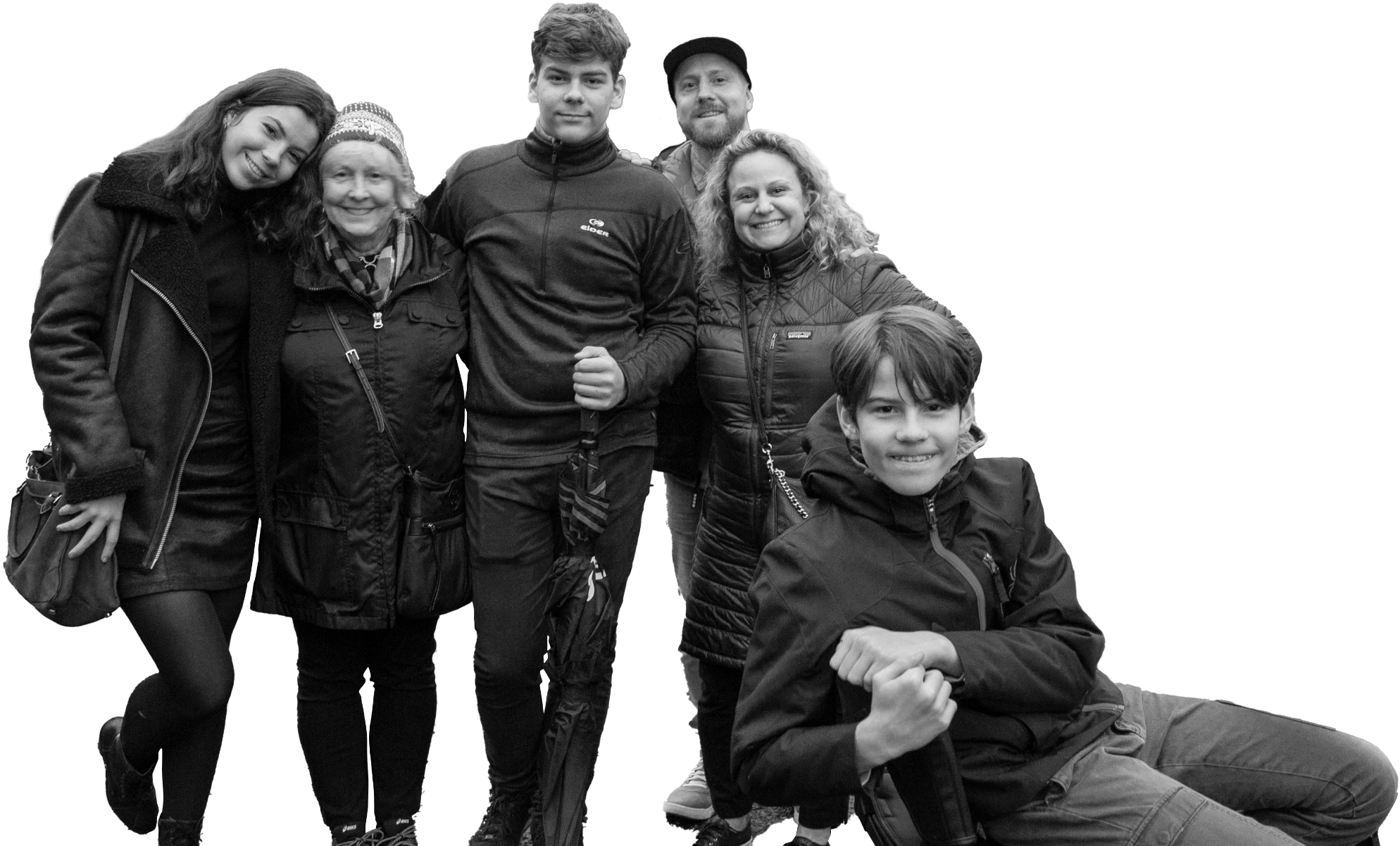 Group family photo of six people, one of whom is seated in a wheelchair and diagnosed with LGMD2I/R9, all smiling and standing closely together